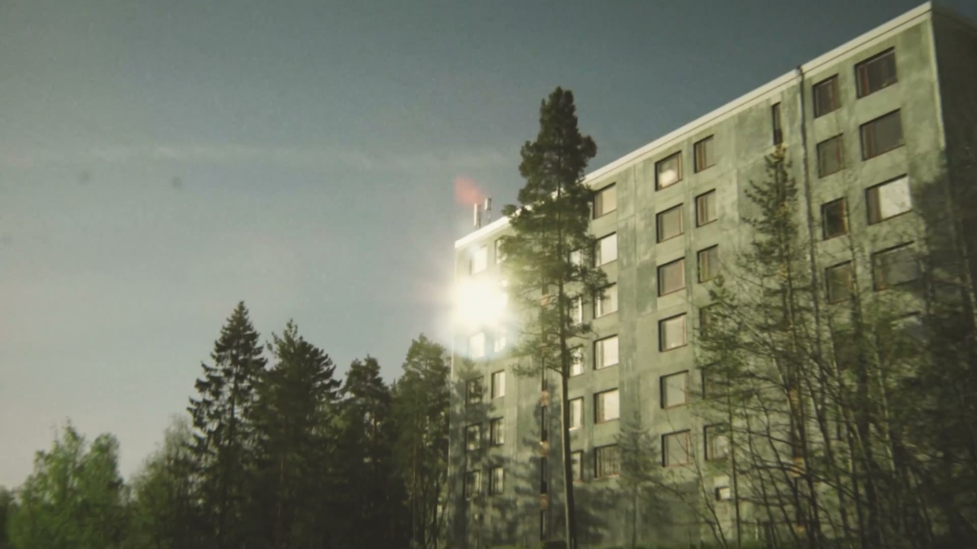 Kerrostalo mäntyjen ympäröimänä Havukoskella auringonvalossa